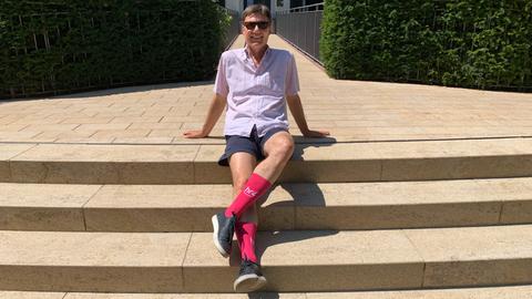Dieter Voss mit den hr4-Socken auf einer Treppe