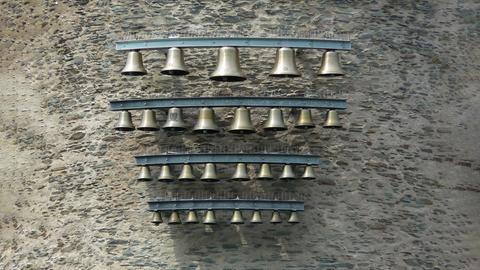 Glockenspiel mit Glocken in verschiedenen Größen an einer Wand