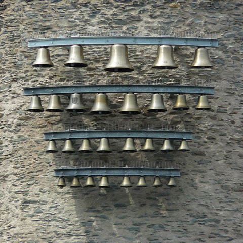 Glockenspiel mit Glocken in verschiedenen Größen an einer Wand