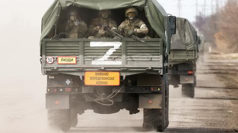 Dieses von der russischen Staatsagentur Tass verbreitete Bild zeigt Uniformierte auf dem Weg zum Kontrollpunkt Perekop die auf der Ladefläche eines Lastwagens sitzen auf den ein weißes Z aufgemalt ist. Das Dorf Perekop liegt auf einer Landenge die die Verbindung zwischen der Krim und dem ukrainischen Festland darstellt. 