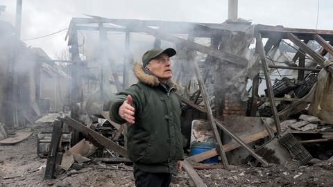 Ein Mann gestikuliert, während er in der Nähe eines durch russischen Artilleriebeschuss zerstörten Hauses in der Nähe der ukrainischen Hauptstadt steht. (06.03.2022)