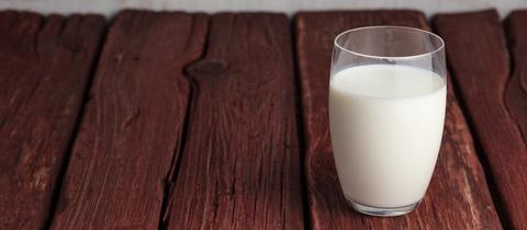 Ein Glas Milch auf einem Holztisch
