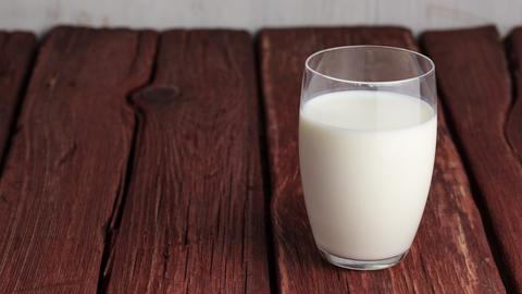 Ein Glas Milch auf einem Holztisch