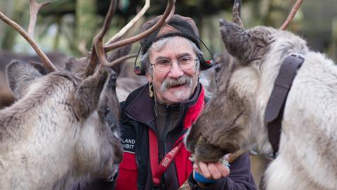 Uwe Kunze, der sich selber als Rentier-Mann bezeichnet, füttert im Lappland-Lager "Björkträsk" im Tierpark Sababurg bei Hofgeismar im Reinhardswald zwei Rentiere.